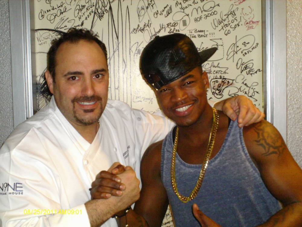 Ne-Yo and executive chef Barry Dakake pose in front of the celebrity “Shake Down Door” at N9NE Steakhouse.