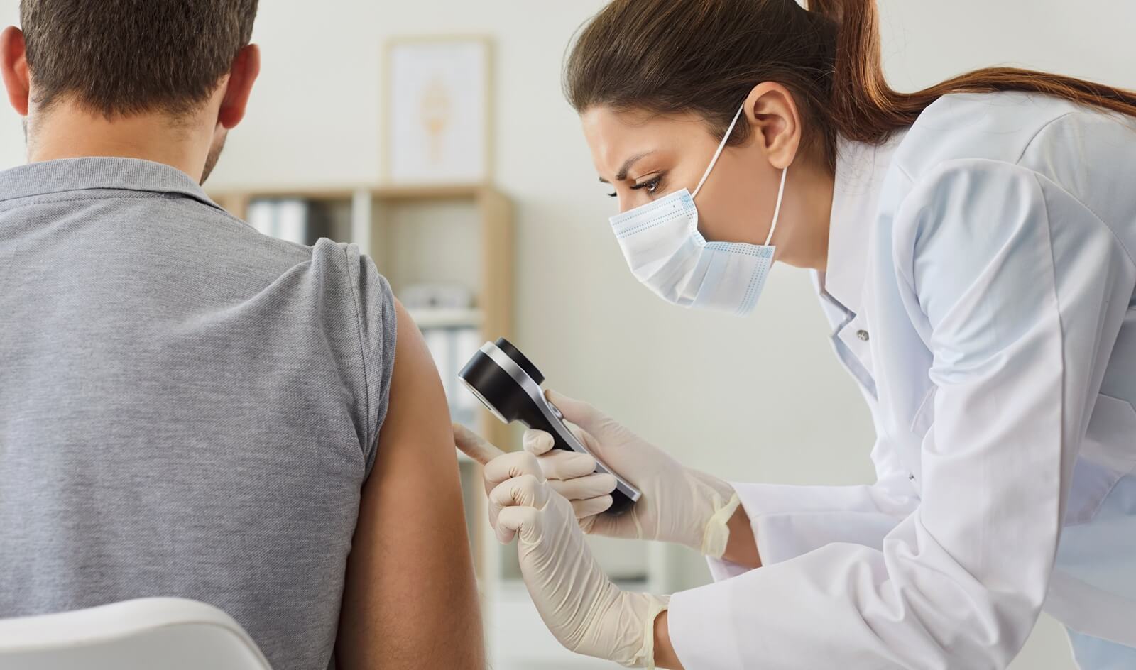 female doctor examining hand skin of young man patient